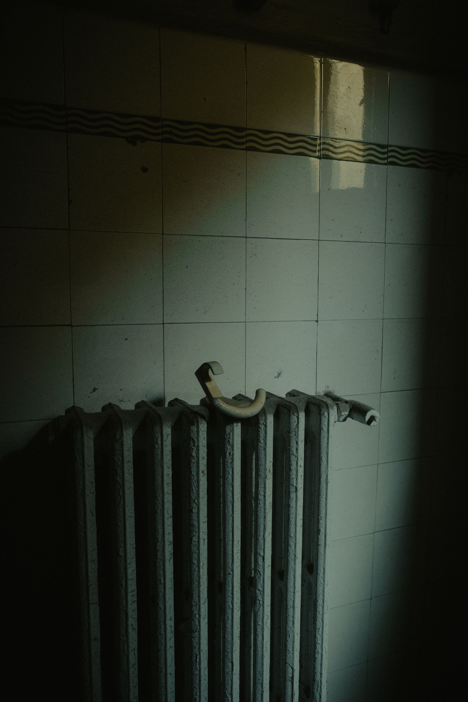 Sample image of an old column radiator against a tiled wall